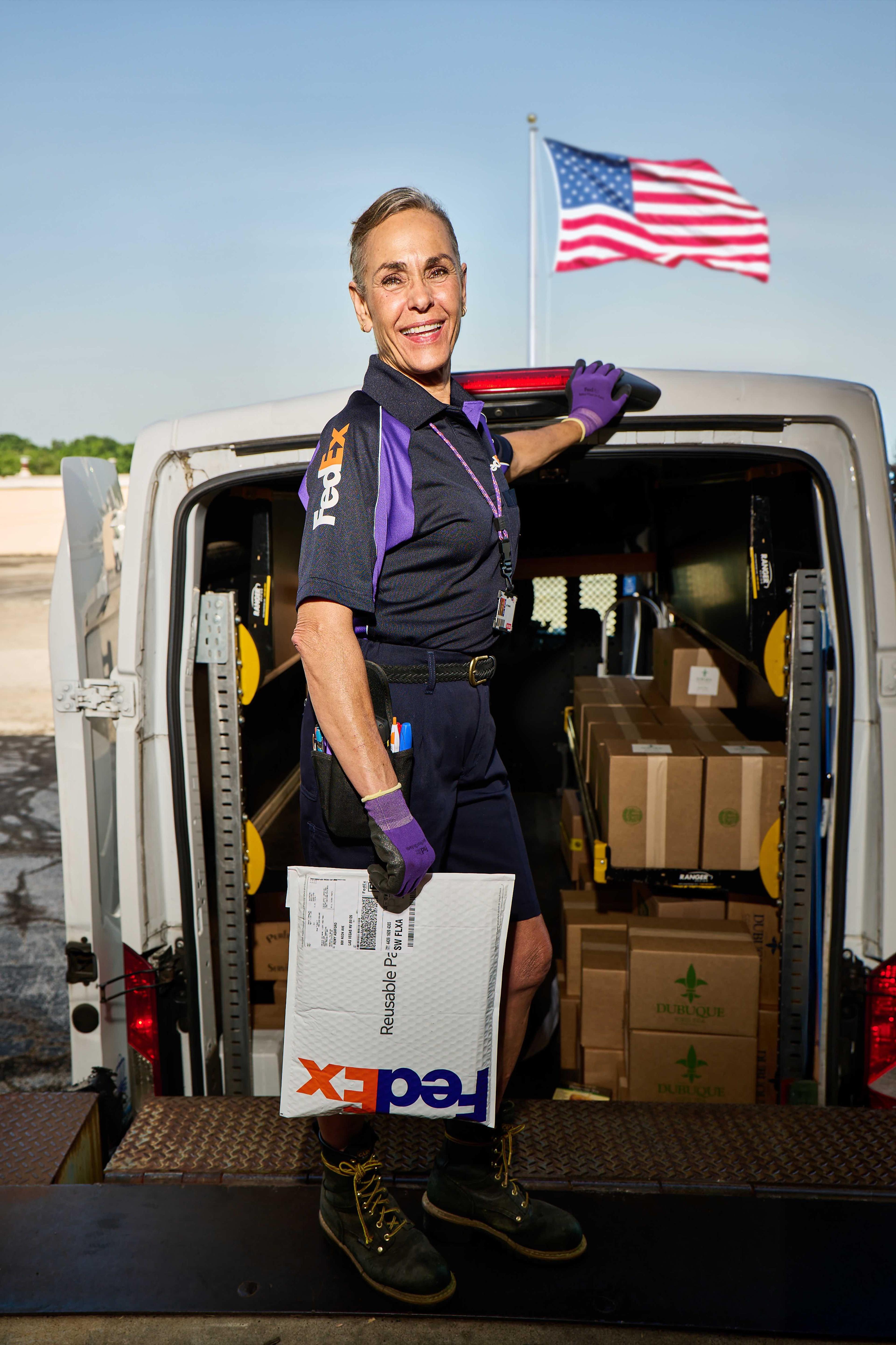 FedEx electric delivery in front of a bridge with a sunset in the background